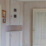 7 of 15 photographs. A view of a china hutch and an interior door with a window and sheer curtains.